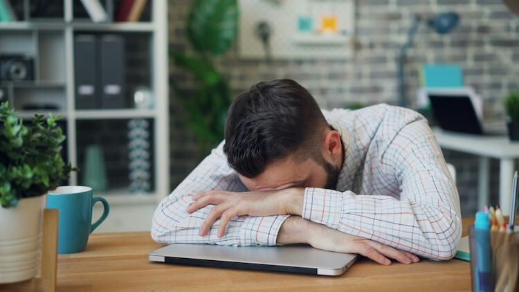 Man with head down on laptop